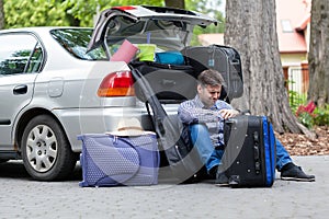 Powerless father next to car trunk