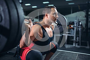 Powerlifter doing squats with barbell in gym photo