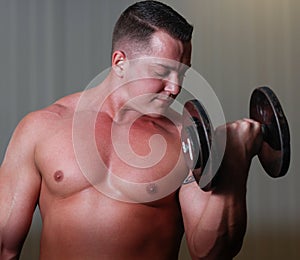 Powerlifter with dumbels in gym