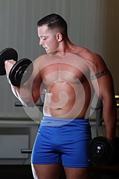 Powerlifter with dumbels in gym