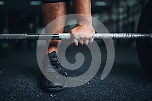 Powerlifter prepares for deadlift a barbell in gym