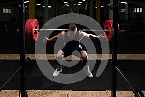 Powerlifter Using Barbell Exercising Legs Inside Gym