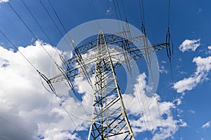 Powerline with electric wires against a blue sky on a sunny day