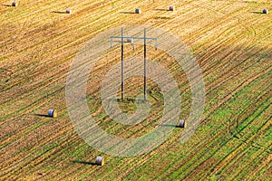 Powerline at a field with round bales