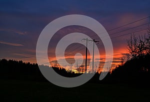 powerline infront of orange sunset with clouds
