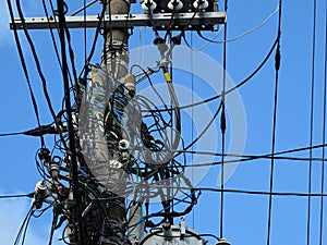 Powerline insulators, connectors and tangled wires on electrical pole