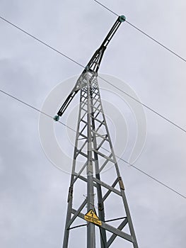 Powerline pole with three cables over a cloudy background