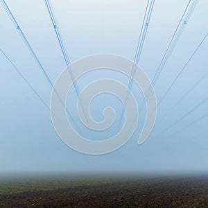 Powerlines in fog over an acre