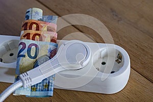 Powerstrip, plugs and Euro banknotes to illustrate the rise of the electricity and daily life expenses