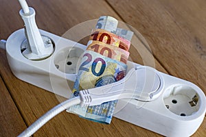 Powerstrip, plugs and Euro banknotes to illustrate the rise of the electricity and daily life expenses