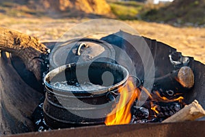 poyke pot. campfire cauldron cooking. making food outside on fire site. shot in israel near hedera olga beach