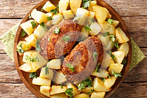 Pozharsky meatballs in breadcrumbs with a side dish of fried potatoes close-up in a plate. horizontal top view