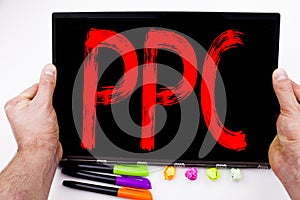 PPC - Pay per Click text written on tablet, computer in the office with marker, pen, stationery. Business concept for Internet SEO