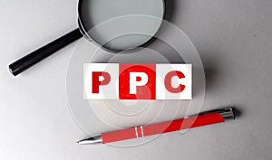 PPC word on wooden cubes with pen and magnifier