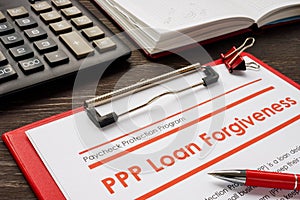 PPP loan forgiveness form and red notebook.