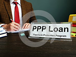 PPP loan and Paycheck Protection Program title on the plate in the office