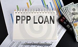 PPP LOAN text written on a notebook with chart,calculator and dollars