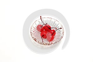 Ppreserving in syrup cherries in a glass bowl isolated on a white background.