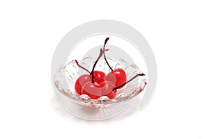 Ppreserving in syrup cherries in a glass bowl isolated on a white background.