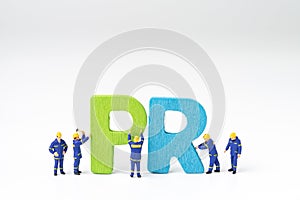 PR, Public Relations concept, miniature people staff help building color wooden letters forming word PR on white background with