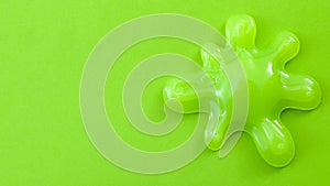 Practical joke splash, funny toy and slime splatter concept with a neon green blob of mucus or goo isolated on white green