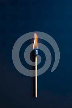 A practically extinguished match on a dark blue background.