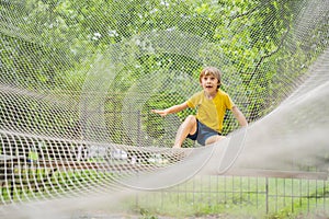 practice nets playground. boy plays in the playground shielded with a protective safety net. concept of children on line