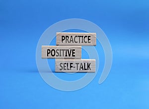 Practice positive self-talk symbol. Concept words Practice positive self-talk on wooden blocks. Beautiful blue background.