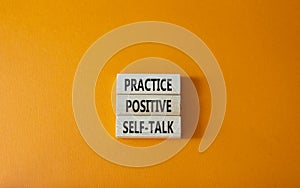 Practice positive self-talk symbol. Concept words Practice positive self-talk on wooden blocks. Beautiful orange background.