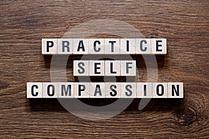 Practice self compassion - word concept on building blocks, text