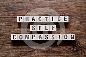 Practice self compassion - word concept on building blocks, text photo
