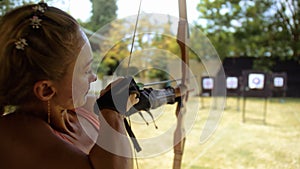 Practice and training of archery in shooting range. Sport woman in shooting range with bow. Outdoor archery training