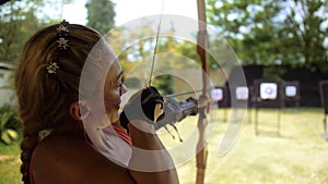 Practice and training of archery in shooting range. Sport woman in shooting range with bow. Outdoor archery training