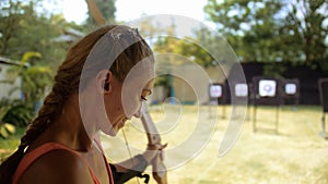 Practice and training of archery in shooting range. Sport woman in shooting range with bow. Outdoor archery training