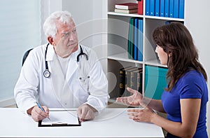 Practiced doctor talking with patient photo