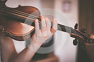 Practicing classical music and violin concept: Young girl happily plays on her new violin