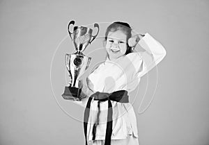 Practicing Kung Fu. happy childhood. small girl with champion cup. martial arts. sport success in single combat. winner