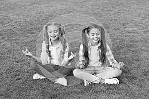 Practicing mudras during meditation. Happy children do meditation on green grass. Small girls enjoy meditation practice