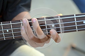 Practicing in playing bass guitar. Close up of man hand playing bass guitar.