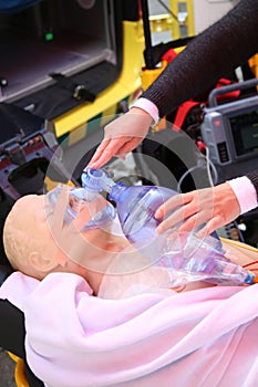 Practicing to use an oxygen mask on training doll