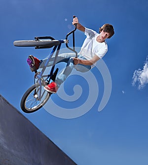 Practicing for the x games. Cropped shot of a teenage boy riding a bmx at a skatepark. photo