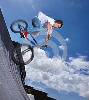 Practicing for the x games. Full length shot of a teenage boy riding a BMX at a skatepark. photo