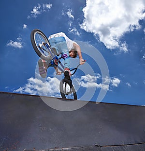 Practicing for the x games. Rearview shot of a teenage boy riding a BMX at a skatepark. photo