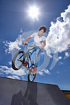 Practicing for the x games. a teenage boy riding a bmx at a skatepark. photo