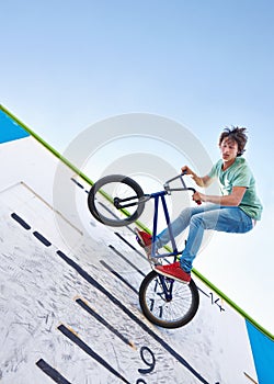 Practicing for the x games. a teenage boy riding a BMX at a skatepark. photo