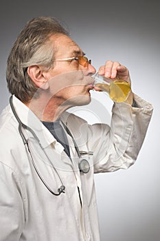 Practicioner in white gown determining disease with test tube of urine