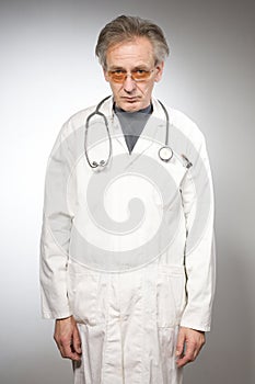 Practicioner in white gown posing in studio isolated on background