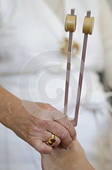 Practitioner giving healing tuning fork treatment.