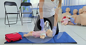 Practitioners training medical learning on a baby mannequin. Giving first aid on a child dummy. First aid training.