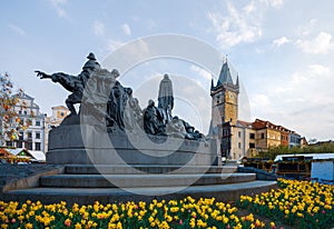 Prague Astronomical Clock behind the Jan Hus Monument surrounded by Daffodils in the middle of Spring